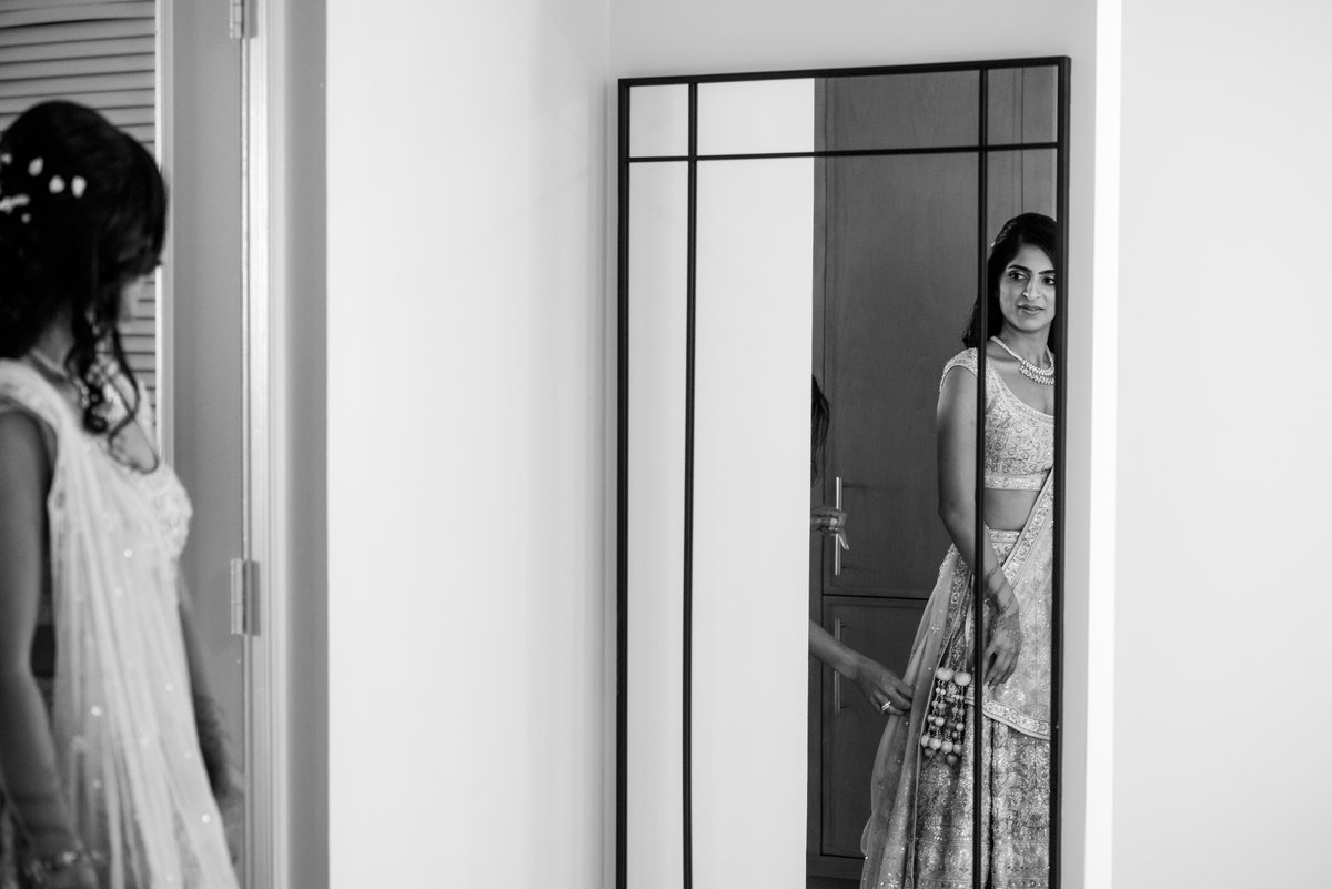 Indian bride getting ready in the mirror, henna on her hands, Amelia Island wedding