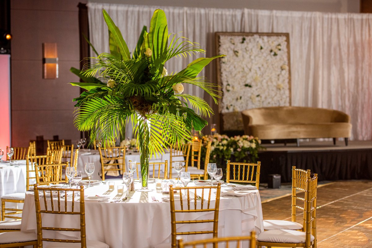 Indian wedding reception ballroom with tropical centerpieces and gold chairs, Ritz-Carlton Amelia Island