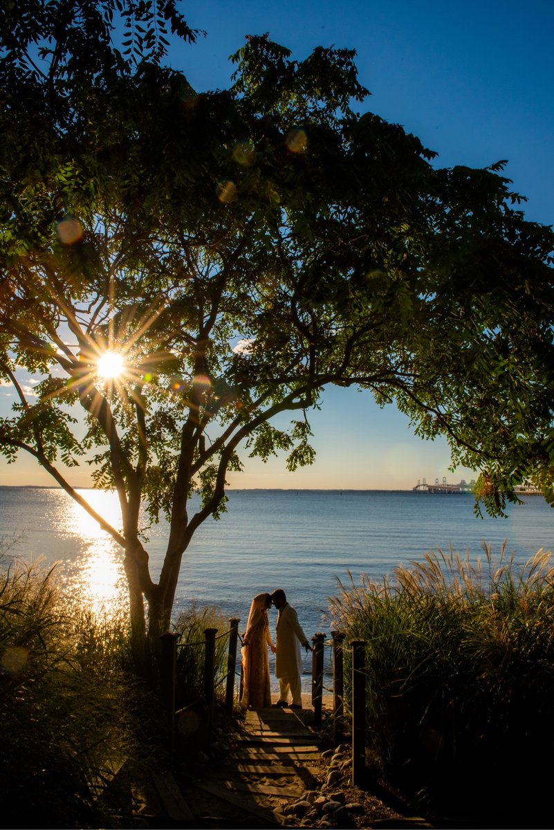 Couple walking toward the water at sunset over the Chesapeake Bay at a Maryland wedding